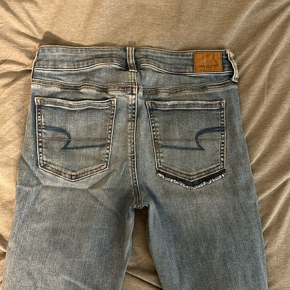American Eagle Light wash medium rise Jegging with holes, asymmetrical pockets
